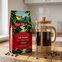 Prensa francesa con café recién preparado y granos alrededor